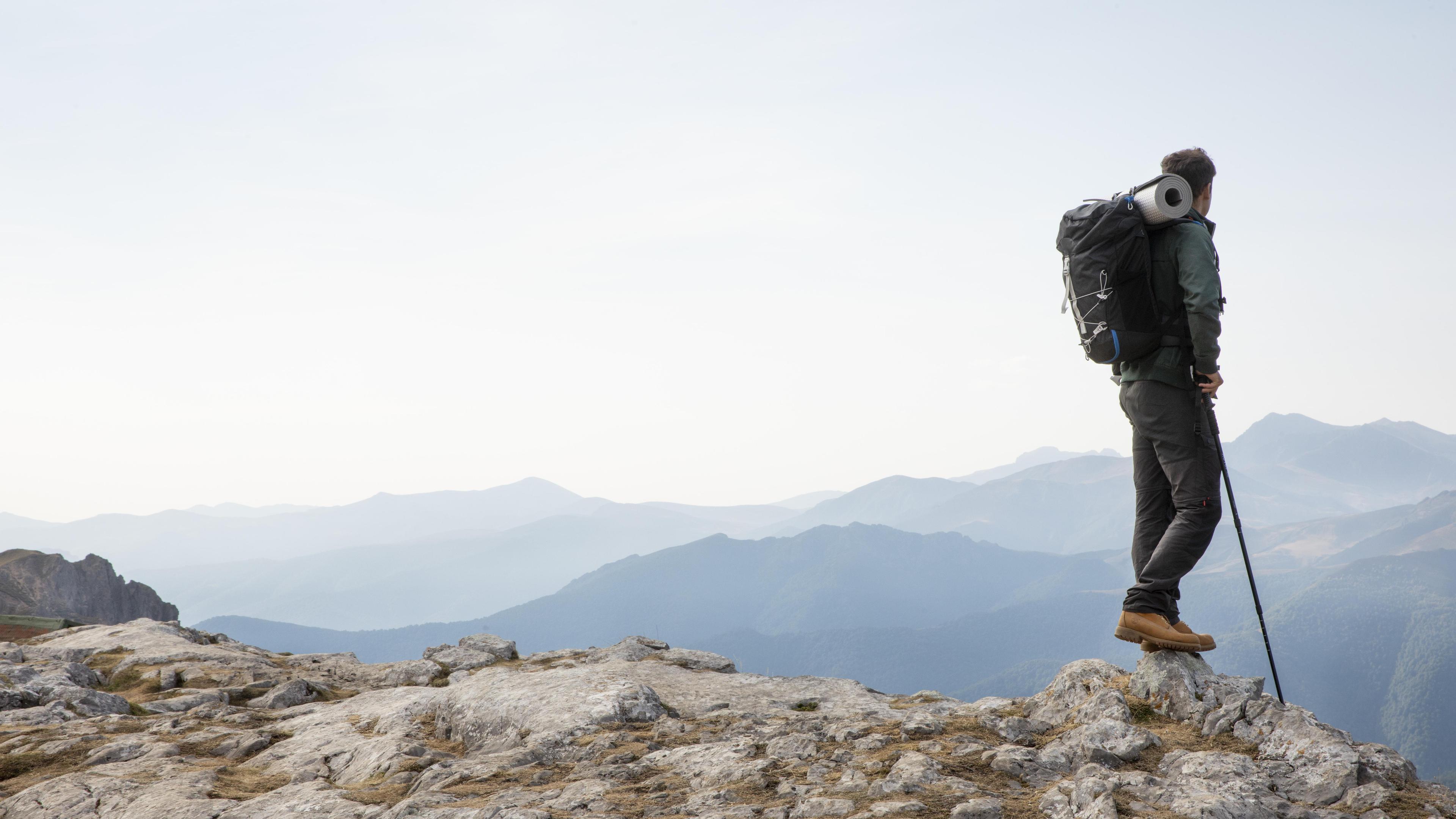 A traveler hiking mountains with a backpack, symbolizing the journey of Immeka Technologies